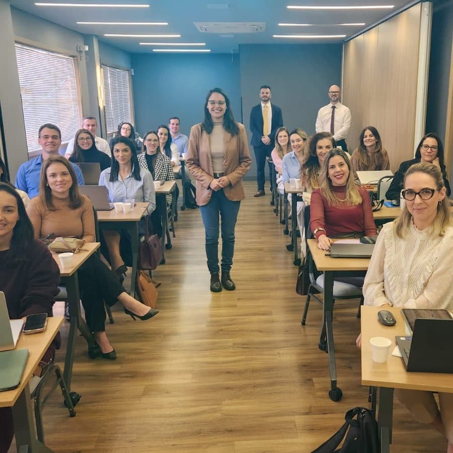 Turma de capacitação em IA reunida em sala, com Nicole Borges ao centro