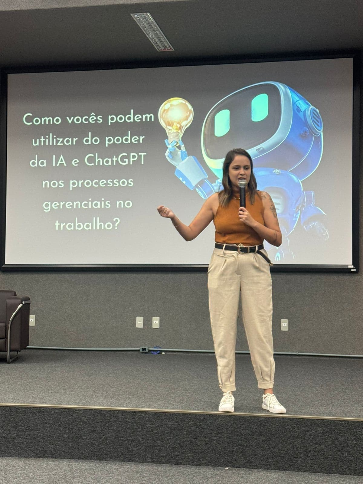 Nicole Borges palestrando sobre IA e ChatGPT em processos gerenciais para um auditório