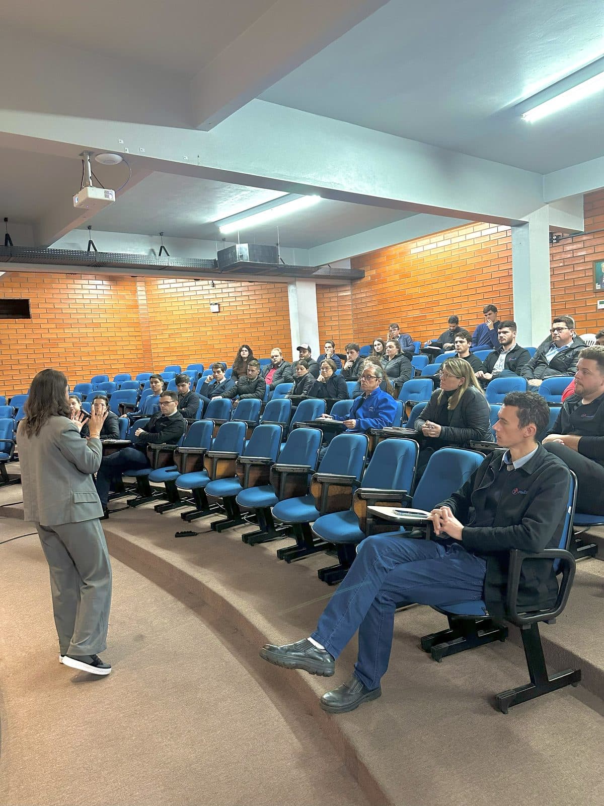 Nicole Borges palestrando sobre IA para plateia em auditório