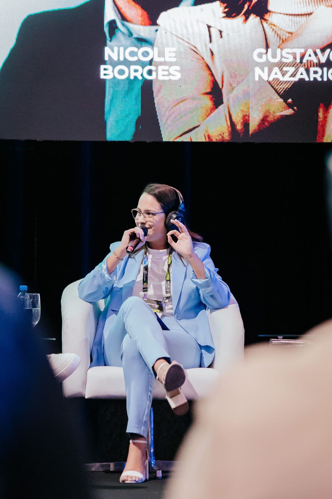 Nicole Borges falando ao microfone em painel de evento de empreendedorismo